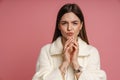 Tricky woman clasping hands isolated over pink background