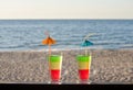 Tricolor cocktail on the bar counter with a sandy beach overlooking the sea Royalty Free Stock Photo