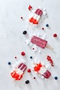 Tricolor homemade strawberry popsicles over ice with berries on marble background, top view Royalty Free Stock Photo