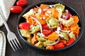 Tricolored tortellini pasta salad on dark wood table Royalty Free Stock Photo