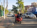 tricycle electric motorcycle. A man is driving through the city. Local resident in Georgia on the road