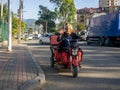 tricycle electric motorcycle. A man is driving through the city. Local resident in Georgia on the road. Kral boss. Gesture of