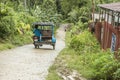 A tricycle goes downhill through a narrow single-lane concrete road. At a remote mountain barangay in Bohol, Philippines