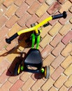 Tricycle for small kids in vibrant colors on diagonal tiled driveway Royalty Free Stock Photo