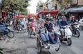 A tricycle takes tourists to travel in various places in the middle of Hanoi, Vietnam