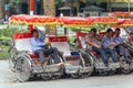 Tricycles with drivers waiting for service on the street in Hanoi, Vietnam