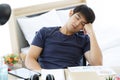 Tried Asian man napping at a office after a hard workday.