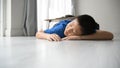 Tried boy sleeping on floor after homework.