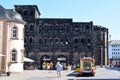 Trier, Germany - 07 11 2023: Porta Nigra with the palce on the city side and a city tour vehicle