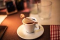 Trieste, Italy - September 2019: Lavazza Espresso cup with Spoon and cookie on a table on a warm summer day in an italian street.