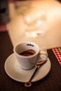 Trieste, Italy - September 2019: Lavazza Espresso cup with Spoon and cookie on a table on a warm summer day in an italian street.