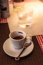 Trieste, Italy - September 2019: Lavazza Espresso cup with Spoon and cookie on a table on a warm summer day in an italian street.