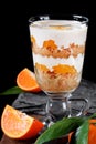Trifle dessert with sponge cake crumbs, mandarin confit and custard served in the glass