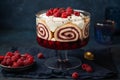 Trifle. Festive layered dessert with berry jelly, swiss roll cake and whipped cream