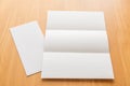 Trifold white template paper on wood background.