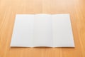 Trifold white template paper on wood background.