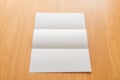 Trifold white template paper on wood background.