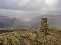 Trig point on Loughrigg Fell overlooking Grasmere with rainbow, Lake District