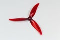 Trilobate red plastic propeller for FPV drone on gray background Royalty Free Stock Photo