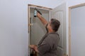 A trim carpenter installs interior doors in a newly constructed house as part of the construction process Royalty Free Stock Photo
