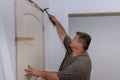 A trim worker uses a hammer when installing interior doors in a new house as part of the installation process Royalty Free Stock Photo