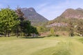 Trimmed golf course, tall trees, private houses and cottages on the mountainside, in the woods Royalty Free Stock Photo