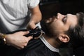 Trimming the beard with a shaving machine. Advertising for barbershop and men& x27;s beauty salon