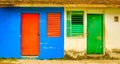 Red door & window on blue wall neighbors green door and window o Royalty Free Stock Photo