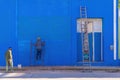 TRINIDAD, CUBA - JANUARY 7, 2021: Cuban worker painting outside of house in blue color on Janaury 7th, 2021 in Trinidad
