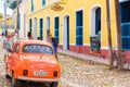 TRINIDAD, CUBA - MAY 16, 2017: Orange retro car on city street. Copy space for text.