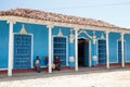 Trinidad, Cuba - people sitting in front of a blue house