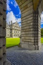 Trinity College Dublin, Ireland. The image features a view of the college through a stone archway, with cobblestones and trees in Royalty Free Stock Photo