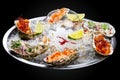 Trio Ceviche, marinated seafood dish, scallop, sea bass, tuna. Haute cuisine. On a black background
