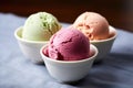 a trio of different-colored ice cream scoops in a bowl