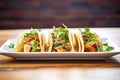 trio of fajita tacos with cilantro garnish in a row