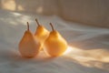 Trio of golden pears glow softly under warm light on a gentle surface Royalty Free Stock Photo