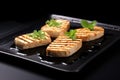 a trio of grilled tofu steaks on a sleek black round plate