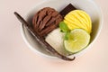 Trio of tasty chocolate vanilla and lime flavored frozen dessert in a white bowl.