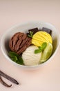 Trio of tasty chocolate vanilla and lime flavored frozen dessert in a white bowl.