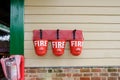 Trio of vintage style Fire Buckets seen attached to a railway waiting room.