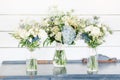 Trio of white floral arrangements in matching vases