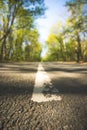 Trip or adventure: Closeup perspective of a street, forest in the blurry background Royalty Free Stock Photo