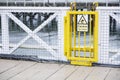 Trip hazard caution sign on ferry ship yellow gate
