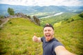 Trip Russia Altay traveler makes selfie photo. Happy young man blogger on background of mountains in summer sunset