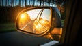 Trip sunset car mirror. Sun, highway car road reflection in mirror. Summer holidays trip concept. Royalty Free Stock Photo