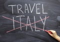 Trip to Italy. A woman`s hand crosses out the inscription Italy on a chalkboard. Cancellation of the tour due to the epidemic