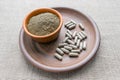 Triphala capsules and powder on clay plate. Triphala is polyherbal Ayurvedic medicine of Indian gooseberry or amalaki; baheda or Royalty Free Stock Photo