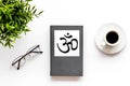 Tripitaka - Buddhist holy book near Om sign - on white table top view