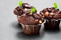 Triple chocolate muffins on black stone background