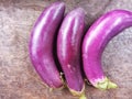 Closeup of Triple Eggplants on Wooden Surface